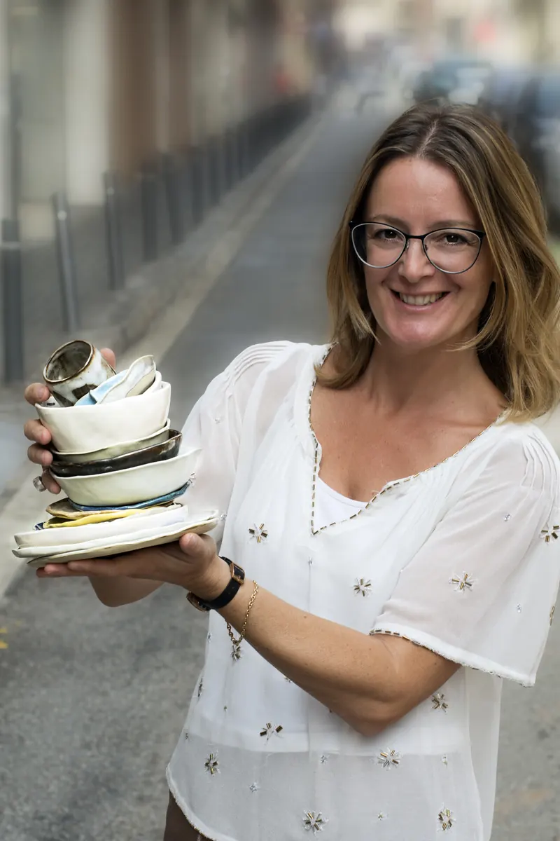 Claudia Capaccio, ceramista de LittleStudio Ceramics, con una pila de cuencos en las manos
